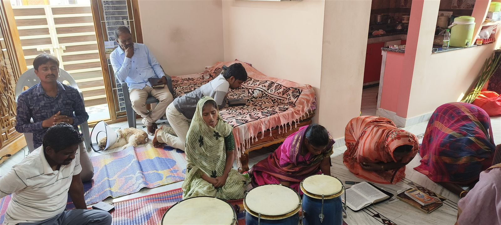 Cottage prayer gathering with an open Bible and worship instruments