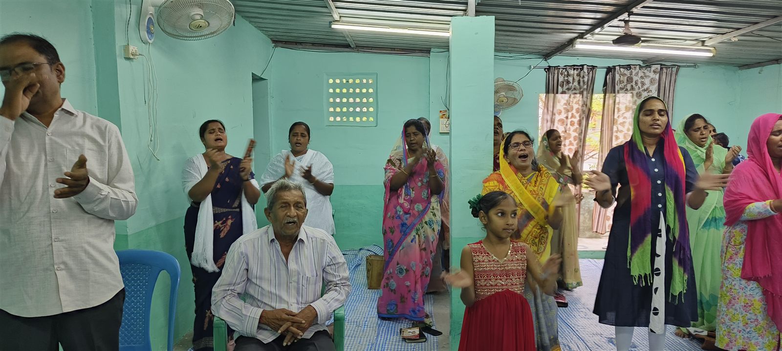 Joyful church worship and prayer gathering at Jesus Praise Ministries